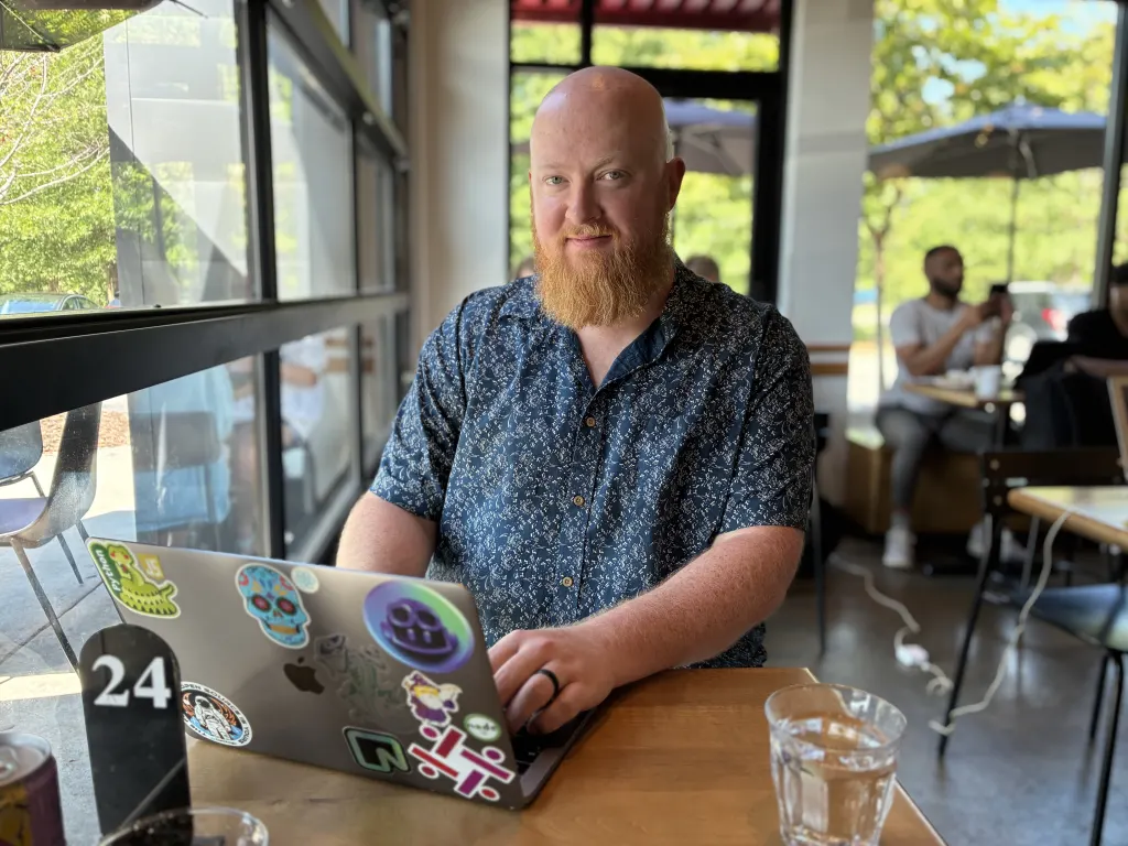 Taylor Kelly, founder of Triangle Web Design, working at a coffee shop in Morrisville, NC
